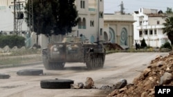 Security forces patrol a street in the district of Al-Waar in the flashpoint city of Homs on May 2.