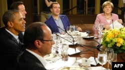 U.S. President Barack Obama (left) is joined by France's Francois Hollande (bottom), Britain's David Cameron (second left), Russia's Dmitry Medvedev (center), and Germany's Angela Merkel at a working dinner at Camp David on May 18.