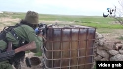 Скриншот размещенного в Сети видео, показывающего русскоговорящих боевиков группировки "Исламское государство" недалеко от города Кобани.