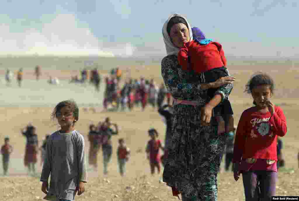 Displaced Iraqis from the minority Yazidi sect walk toward the Syrian border as they flee attacks by the Islamic State militant group on August 11. (Rodi Said, Reuters)