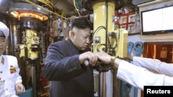 Sjevernokorejski lider Kim Jong Un gleda kroz periskop podmornice tokom inspekcije pomorske jedinice Korejske narodne armije (KPA),na nepoznatoj lokaciji