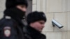Полицейские проходят мимо уличной камеры в Москве. Россия, 2020 год