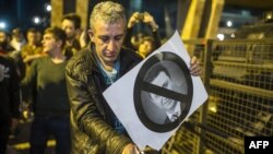 Demonstrant pali sliku Nikole Gruevskog na protestima u Skoplu, 15. april 2016.
