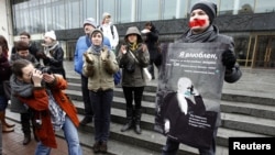 A gay-rights activist holds a placard displaying the image of 19th-century composer Pyotr Tchaikovsky during an unsanctioned protest rally to defend the rights of Russian gays and lesbians in St. Petersburg on April 7.