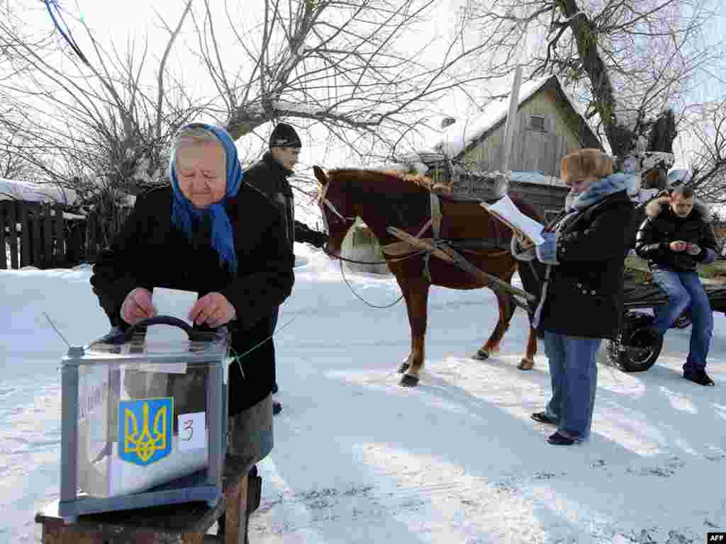 Літня жінка вкидає бюлетень в селі Дитятки біля Чорнобильської зони