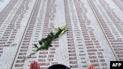 A Muslim woman prays at the Potocari memorial cemetery, near Srebrenica, in March 2010.