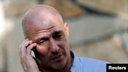 New York Times reporter Matthew Rosenberg, 40, talks on his phone after an interview in Kabul, August 20, 2014.