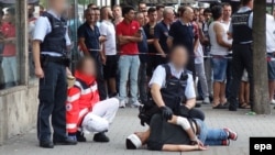 Полиция арестовывает мужчину, пытавшегося зарубить мачете жителей города Rutlingen, 24 июля 2016 года 
