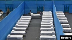 Radnici postavljaju krevete u zoni karantina unutar sportskog kompleksa u Guvahatiju, Indija, 29. mart, 2020. 