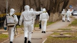 Көшеде коронавирусқа қарсы дезинфекция жасап жүрген адамдар. Орал, 18 сәуір 2020 жыл.