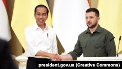 Indonesia's president, Joko Vidodo (left), says he was given the message from Ukrainian President Volodymyr Zelenskiy (right) during a stopover in Kyiv on June 29.
