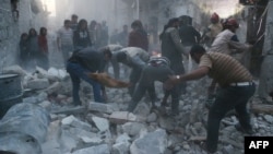 Syrian civil defense workers and pedestrians clear debris after a suspected Syrian government air strike in the Bab al-Nairab neighborhood in the northern Syrian city of Aleppo on November 12.