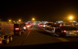 Romanian and Bulgarian cars line up to cross the border between Hungary and Romania at the border station of Nagylak, Hungary, on the morning of March 18.