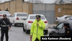 Озарбайжон полициячиси ёнғин бўлган ҳудудга олиб борувчи йўлни назорат қилмоқда.