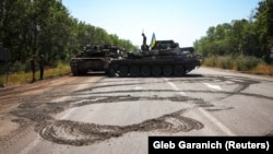 Украинская военная техника видна на дороге недалеко от линии фронта в Донбассе. Июль 2022 года