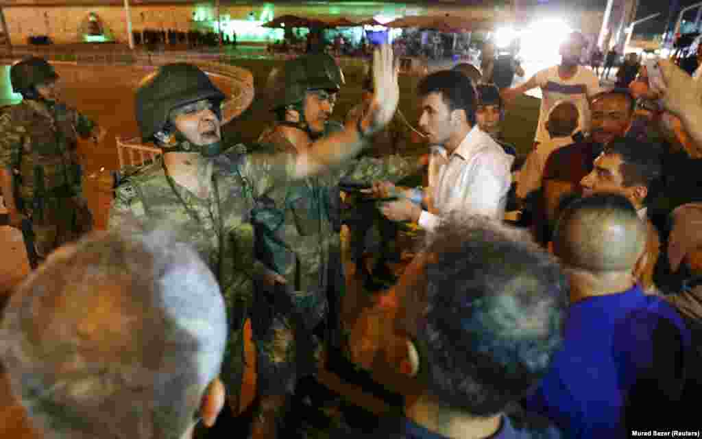 Turkish soldiers are surrounded by civilians in Taksim Square in Istanbul. Meanwhile, in the capital, Ankara, reports came in of gunfire and military aircraft flying over the city at around 8 p.m. on July 15.