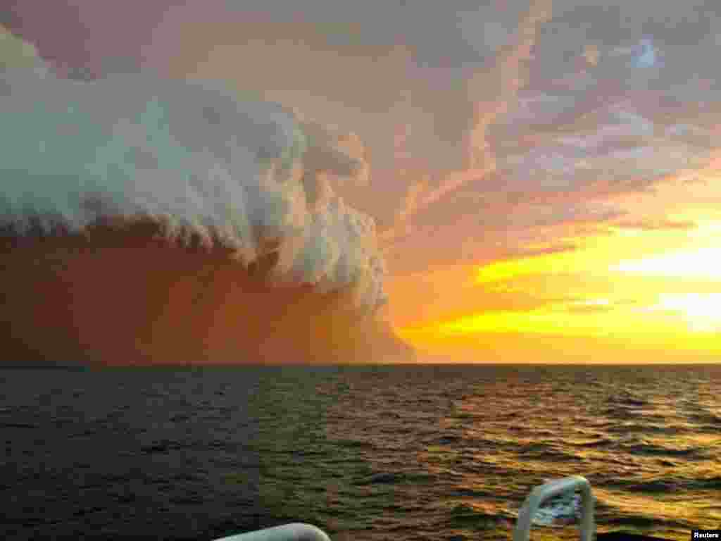 Furtună de nisip roșu cu coroană de nori călătorind &icirc;n Oceanul Indian.