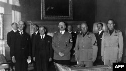 Prime Ministers (left to right) Lord Neville Chamberlain of the United Kingdom and Edouard Daladier of France, German Chancellor Adolf Hitler, Italian Prime Minister Benito Mussolini and Foreign Minister Count Gian Galeazzo Ciano gather in Munich on September 29, 1938, to sign the Munich treaty between Nazi Germany, France, Italy, and the United Kingdom, authorizing Hitler to annex the Czech territory called the Sudetenland.
