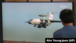 სამხრეთი კორეა, 2019 წლის 24 ივლისი: სეულის რკინიგზის სადგურში ერთ-ერთი მგზავრი უყურებს ტელეგადაცემას სამხრეთ კორეის საჰაერო სივრცეში რუსეთის საბრძოლო თვითმფრინავის შეჭრის შესახებ