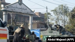 PAKISTAN -- Pakistani security personnel take position outside an Agriculture Training Institute after an attack by Taliban militants in Peshawar, December 1, 2017