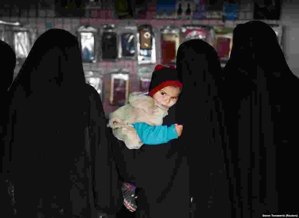Женщина с ребенком на руках в магазине на территории лагеря аль-Холь.