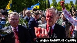 Посла Росії у Польщі Сергія Андрєєва (праворуч) облили червоною фарбою під час церемонії покладання вінка на цвинтарі, де поховані солдати Червоної армії. Варшава, 9 травня 2022 року 