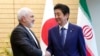 Iranian Foreign Minister Mohammad Javad Zarif, left, and Japanese Prime Minister Shinzo Abe, right, shake hands at Abe's official residence in Tokyo Thursday, May 16, 2019. (AP Photo/Eugene Hoshiko, Pool)