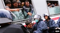Хорват полициясы Венгрия мен Австрияға жолғы шыққалы тұрған поезға терезінен кірмек болған босқынды жібермей тұр. Товарник, Хорватия, 21 қыркүйек 2015 жыл.