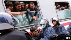 Хорватская полиция не позволяет мигранту залезть в окно поезда, отправляющегося в Венгрию и Австрию. Товарник, Хорватия, 21 сентября 2015 года. 