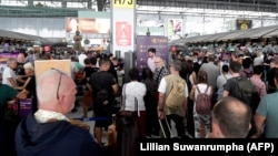 Stranded passengers wait at the check-in area at the Suvarnabhumi International Airport in Bangkok on February 28.