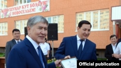 А.Атамбаев и А.Сегизбаев во время вручения ключей от квартир сотрудникам ГКНБ
