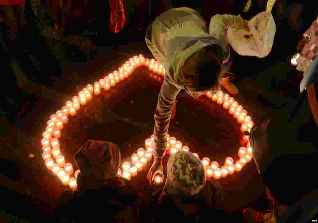 A woman adds candles to a heart shape to honor Vaclav Havel on Prague's Wenceslas Square on the first anniversary of the late Czech president's death on December 18. (epa/Filip Singer)