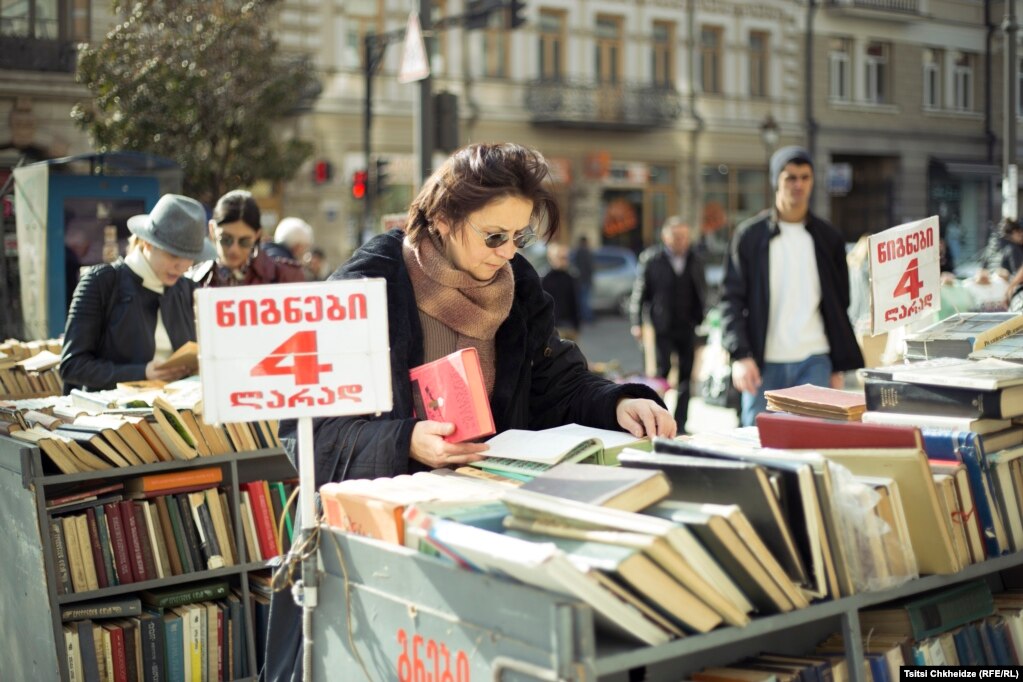 Девушка рассматривает подержанные книги в центре Тбилиси. Фото: Indigo Fleur