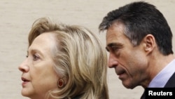 U.S. Secretary of State Hillary Clinton (left) and NATO Secretary-General Anders Fogh Rasmussen arrive at a NATO defense and foreign ministers' meeting at alliance headquarters in Brussels.