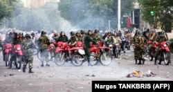 Iranian police sit on motorcycles as they face protesters during a demonstration in Tehran on June 20, 2009.
