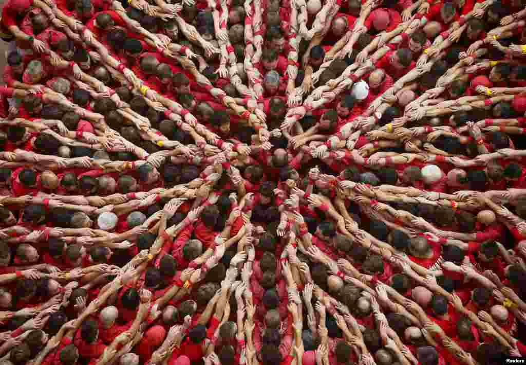 Castellers Colla Joves Xiquets de Valls start to form a human tower called a &quot;castell&quot; during a biannual competition in Tarragona, Spain. The formation of human towers is a tradition in the area of Catalonia. (Reuters/Albert Gea) 