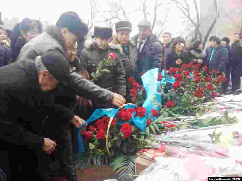 «Тәуелсіздік таңы» ескерткішіне гүл қойып жатқан қарапайым адамдар.