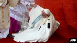 Папе римскому Франциску помогают подняться после падения