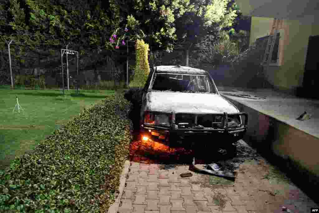 A burned-out vehicle smolders inside the U.S. Consulate compound.