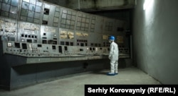 A man looks at the fungus-coated control desk of the Chernobyl nuclear power plant.