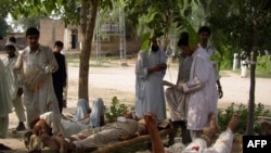 Victims are treated outside a hospital following a suicide bomb attack targeting a police station in Lakki Marwat.