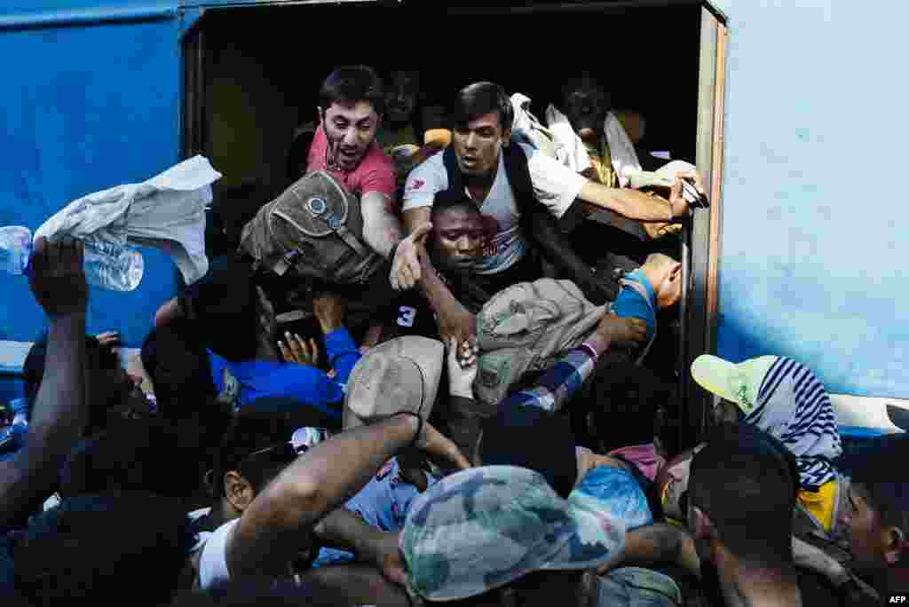 Migrants rush as they try to get on a train heading to the border with Serbia at a train station in Gevgelija on the Macedonian-Greek border. Non-EU Serbia's frontier with Hungary, which is in the bloc's passport-free Schengen zone, has become a major crossing point for huge numbers of migrants entering the EU. (AFP/Dimitar Dilkoff)