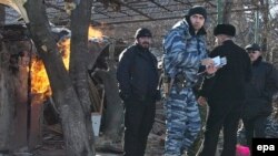 Soldiers and police work at a house destroyed during a special operation in Grozny. Critics say Moscow's military approach to the region's problems is self-defeating.