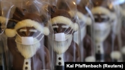 Шоколадные фигурки Санта Клауса в маске, изготовленные германскими кондитерами к Рождеству. Франкфурт, 23 ноября 2020 года.