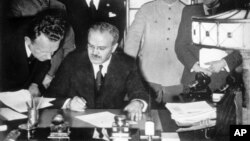 Soviet Foreign Minister Vyacheslav Molotov (seated) signs the German-Soviet non-aggression pact in Moscow on August 23. 