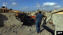 مردی در حال تماشای خرابه‌های باقی‌مانده از نبردهای اخیر در بنغازی، میان نیروهای وابسته به دولت مرکزی لیبی و «حکومت اسلامی» و برخی دیگر گروه‌های اسلام‌گرا است