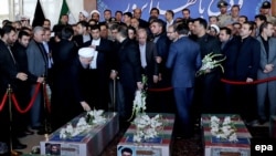Iranian President Hassan Rohani (left) attends the funeral of victims of a terror attack on the Iranian parliament in Tehran on June 9, 2017.
