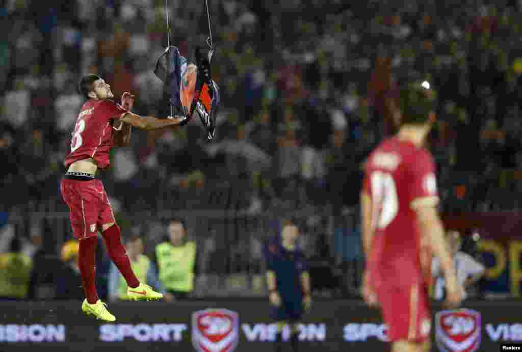 Igrač Srbije pokušava da uhvati albansku zastavu koju nosi mala letelica na daljinsko upravljanje iznad terena Stadiona Partizana u Beogradu. 