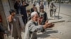 A man who was injured in a car bomb blast talks to people at the scene in Kabul on August 7.
