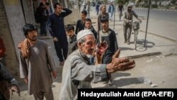 A man who was injured in a car bomb blast talks to people at the scene in Kabul on August 7.